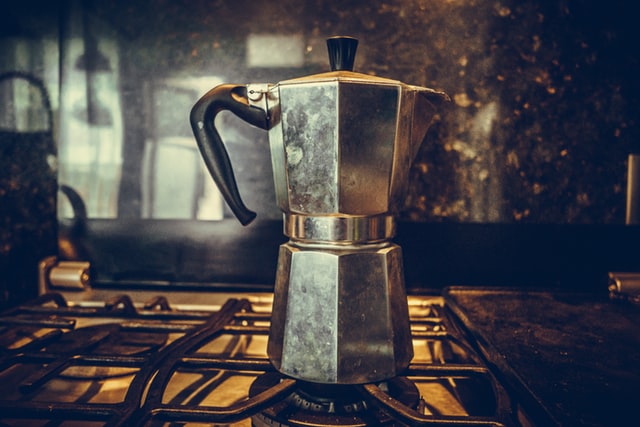 Coffee being brewed in a moka pot on a gas stovetop