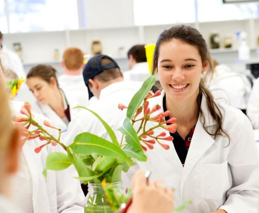 Image of student smiling in a lab coat