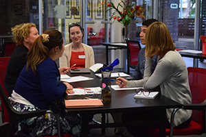 Staff seated around table in discussion