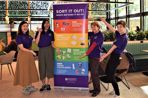 Student volunteers inside Physiol refectory with recycling signs