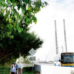 Image of students at the UQ Lakes bus stop, walking over the Green Bridge