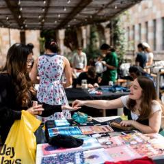Image of most recent UQ Preloved stall and Repair Café. Photo of student paying for preloved clothes.