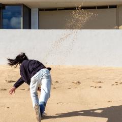 Drew Kahuʻāina Broderick. “a handful of sand thrown against a white wall after work, amidst a rising tide”, 2020, Performance documentation, Waikīkī, Kona, Oʻahu. Courtesy of the artist, Honolulu. 