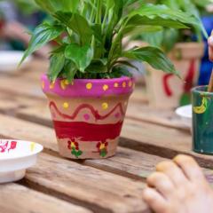 Image of plant pot being painted in bright colours.