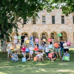 Image of UQ students standing in the Great Court in front of the sandstone Forgan Smith building holding 17 cubes representing the 17 Sustainable Development Gaols set out by the United Nations